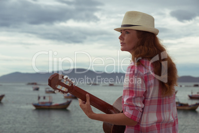 beautiful red-haired girl with a guitar