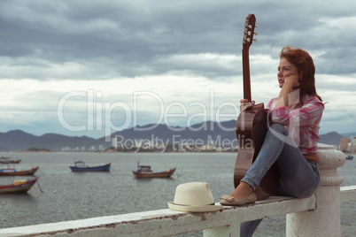 beautiful red-haired girl with a guitar