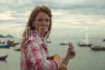 beautiful red-haired girl with a guitar