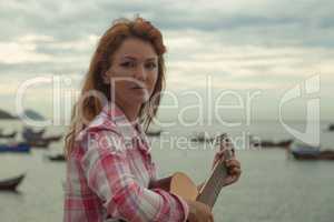 beautiful red-haired girl with a guitar