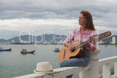 beautiful red-haired girl with a guitar