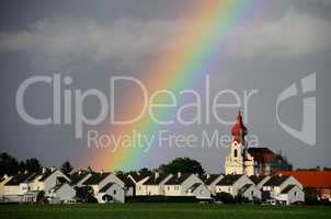 regenbogen im dorf mit kirche