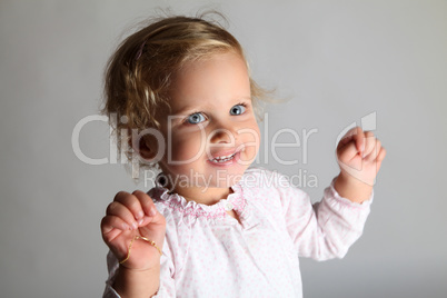 kleines Mädchen Kind mit Armkette singt und lacht