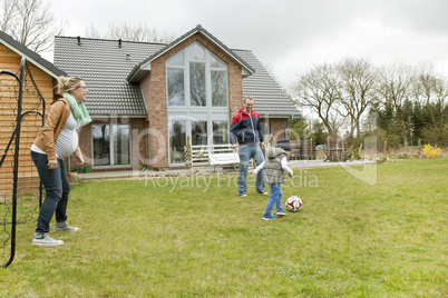 Familie spielt Fussball im Garten