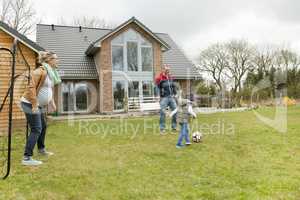 Familie spielt Fussball im Garten