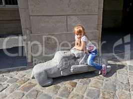 Small girl sitting on the lions sculpture
