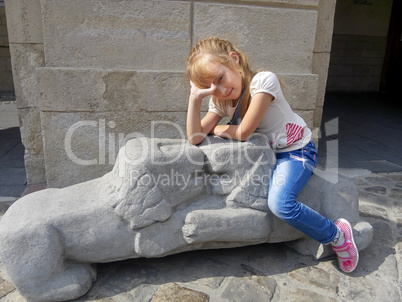 Little girl sitting on the lions sculpture