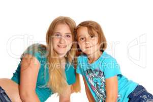 Two little sisters lying on the floor.