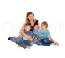 Mother with her three kids sitting on floor.