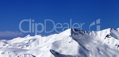 Panoramic view on off-piste snowy slope at sunny day