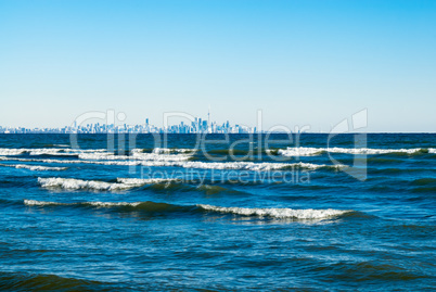 Waves breaking on lake with Toronto skyline in distance