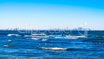 Waves breaking on lake with Toronto skyline on distant horizon