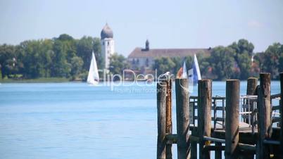 Gull sitting at a pier in front of Frauenchiemsee, Bavaria