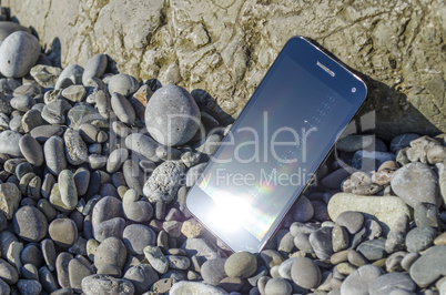 Smartphone On The Pebbly Sea Beach