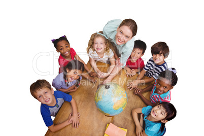 Composite image of cute pupils smiling around a globe in classro