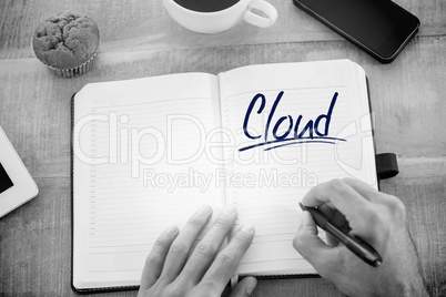 Cloud against man writing notes on diary