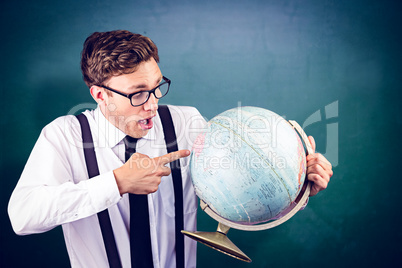 Composite image of geeky businessman pointing to globe