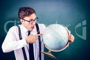 Composite image of geeky businessman pointing to globe