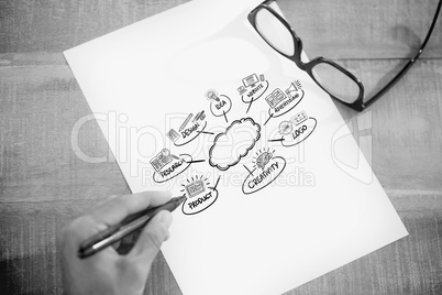 Composite image of left hand writing on white page on working de
