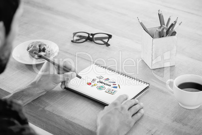 Composite image of creative businessman writing notes on noteboo