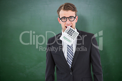 Composite image of geeky businessman biting calculator