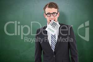 Composite image of geeky businessman biting calculator