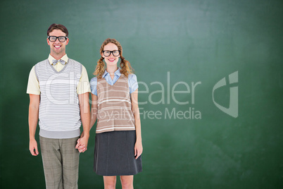 Composite image of smiling geeky hipster couple holding hands Composite image of smiling geeky hipster couple holding hands