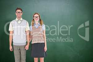 Composite image of smiling geeky hipster couple holding hands