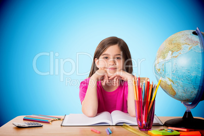 Composite image of cute pupil working at her desk