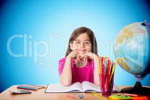 Composite image of cute pupil working at her desk