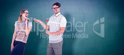 Composite image of geeky hipster holding rose and pointing his g