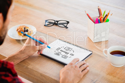 Composite image of creative businessman writing notes on noteboo