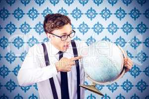 Composite image of geeky businessman pointing to globe