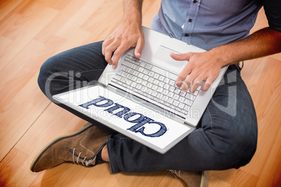 Cloud against young creative businessman working on laptop