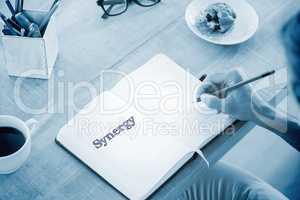 Synergy against man writing notes on diary