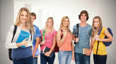 Composite image of a smiling girl standing in front of her frien