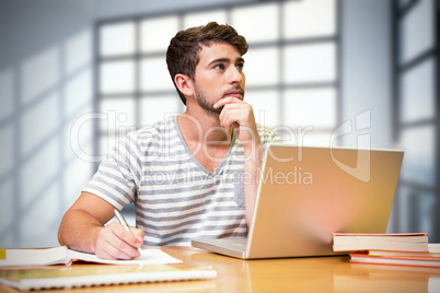 Composite image of student studying in the library with laptop