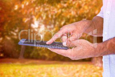 Composite image of a man using tablet computer