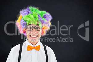 Composite image of geeky hipster wearing a rainbow wig