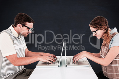 Composite image of geeky hipster couple using laptop