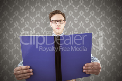 Composite image of geeky student reading a book