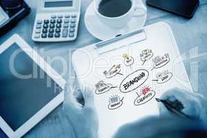 Composite image of man writing on clipboard on working desk