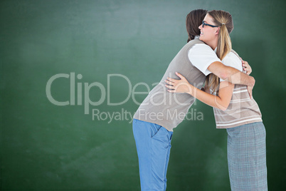Composite image of geeky hipster couple hugging