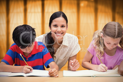 Composite image of pretty teacher helping pupils in library