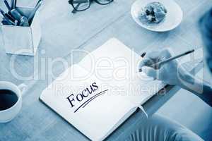 Focus against man writing notes on diary