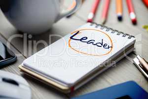 Leader against notepad on desk