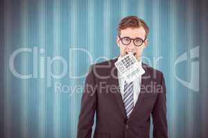 Composite image of geeky businessman biting calculator