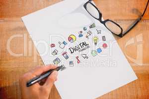 Composite image of left hand writing on white page on working de