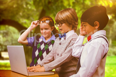 Composite image of pupils using laptop