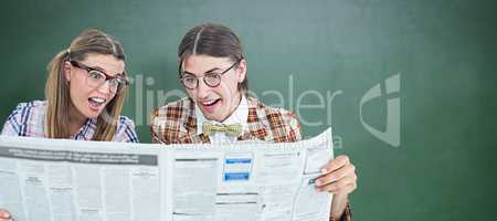 Composite image of geeky hipsters reading the newspaper